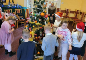 Dzieci ubierają świąteczne drzewko
