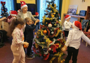 Dzieci ubierają świąteczne drzewko