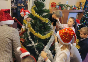 Dzieci ubierają świąteczne drzewko