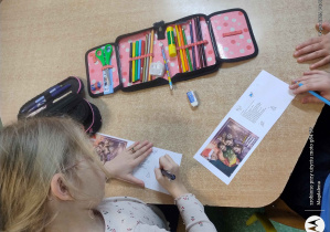 Uczennica wypisuje na kartce swoje imię