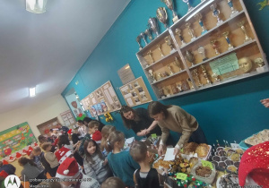 Uczniowie zwiedzający jarmark i robiący drobne zakupy