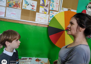 Nauczycielka i uczeń przed kolorowym kołem fortuny