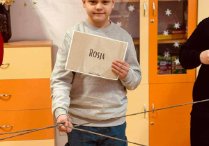 Uczeń trzyma fiszkę z nazwą państwa