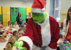 Mikołaj Grinch wręcza dzieciom prezenty