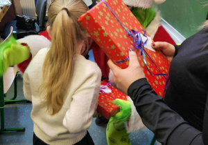 Upominek w czerwonym papierze ozdobiony kokardą