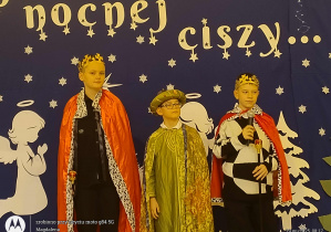 Na tle dekoracji uczniowie jak Trzej Królowie