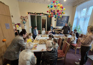 Dzieci na tle wnętrza pokoju - u sufitu kolorowy "pająk"