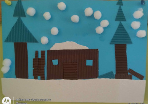 Praca plastyczna dom i drzewa na niebieskim tle, śnieżynki z białych małych pomponików