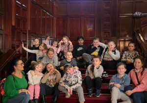 Uczniowie siedzą na stopniach klatki schodowej Pałacu Poznańskiego