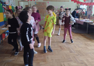 Poprzebierane karnawałowo dzieci bawią się na parkiecie