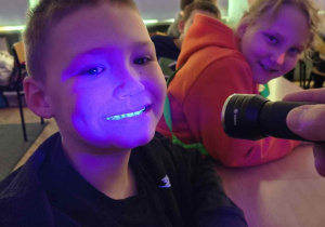 Chłopiec i latarka optycznie wybielająca zęby