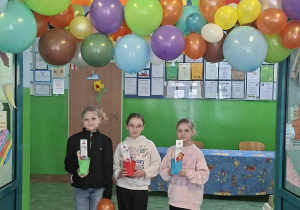 Uczniowie na tle kolrowej dekoracji "Kraina zabawy i nauki" witają naszych gości