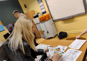 W sali informatycznej, nauczycielka pokazuje dziecku interaktywną kolorowankę