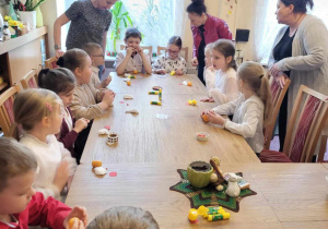 Uczniowie przy stole, przed nimi elementy do pracy plastycznej kurczaczka