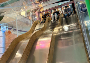 Wysokie zjeżdzalnie a na ich szczycie uczniowie czekający na swoją kolej