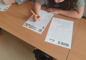 Ławka a na niej karta z zadaniami konkursowymi z języka angielskiego uczniów klas starszych