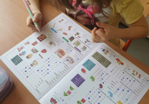 Uczennica z klas młodszych rozwiązuje zadania konkursowe