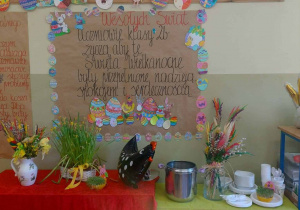Dekoracje w postaci gazetki ściennej z życzeniami oraz wielkanocne przysmaki na stołach