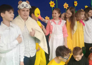 Wspólne zdjęciu uczniów w ich scenicznych kostiumach: baranki, kurczaczki, zajączki, gospodynie w kolorowych spódnicach