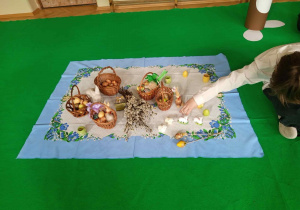 Dekoracja- obrus a na nim tradycyjne wielkanocne potrawy i ozdoby