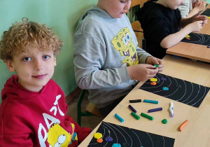 Uczniowie przy pracy stolikowej - kolorują Układ Słoneczny
