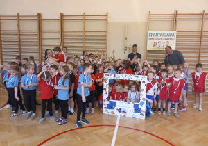 Przedszkolaki z różnych przedszkoli, w kolorowych koszulkach,ustawiają się do zdjęcia