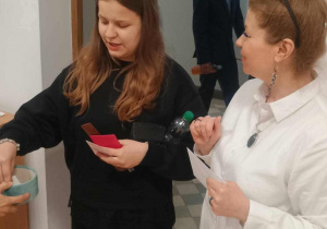 Uczennica losuje numerek stolika