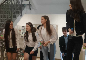 Uczniowie w galowych strojach wchodzą po schodach
