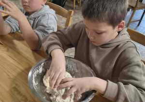 Chłopiec wyrabia ciasto