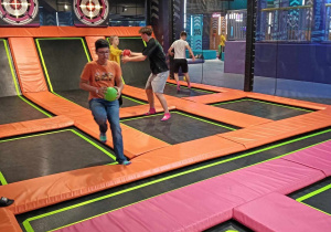 Chłopiec biegnie z piłką między trampolinami