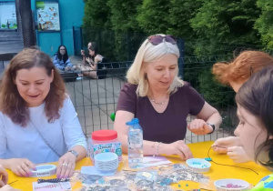 Panie nauczycielki i uczennica podczas wykonywania breloczków