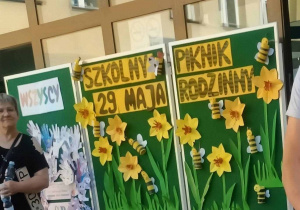 Tablica z dekoracją informującą o pikniku - żółty napis w otoczeniu żonkili i pszczółek z papieru