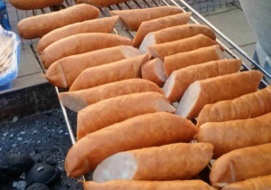 grill pełen równiutkich kiełbasek przygotowanych do pieczenia