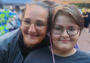 Mama z synem na tle budynku szkoły