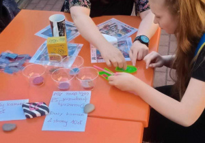 Nauczycielka i uczennica pochylone nad manualnym zadaniem sprawnościowym