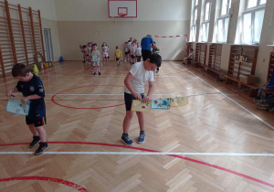 Sportowa rywalizacja - ćwiczenie manualne - wieszają za pomocą klamerek kolorowe chusteczki na rozciągniętym sznurze