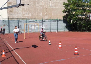 Rowerzysta pokonuje tor przeszkód - przejeżdza między pachołkami