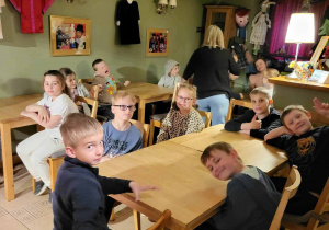 DZieci przy stolikach, na ścianach kolorowe lalki