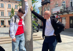 Uczeń i przewodnik przy pręgierzu na rynku