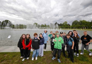 Zdjęcie grupowe, za osobami bardzo rozległe jezioro z dużą fontanną