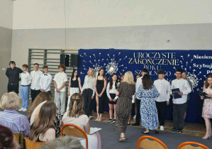 Uczniowie klasy 8b odbierają dyplomy, świadectwa i gratulacje