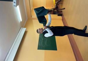 Magik trzyma w ręku rzedmiot zakryty zielonym materiałem