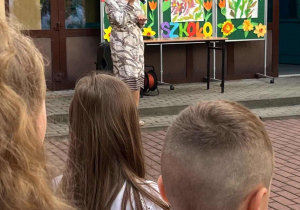 Pani dyrektor na dziedzińcu wewnętrznym - w tlena tablicach dekoracja z kolorowymi kwiatami