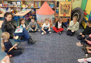 Nauczyciel i dzieci w kręgu na dywanie