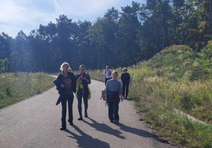 Wędrówka po drodze asfaltowej, wśród błękitu nieba i zeleni wokół